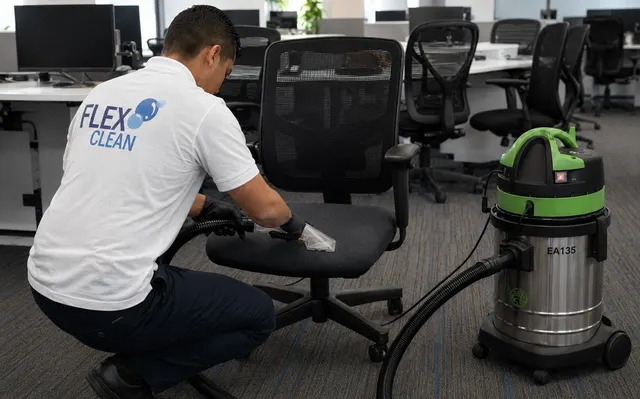 Técnico da Flex Clean higienizando cadeira de escritório com extratora, removendo manchas